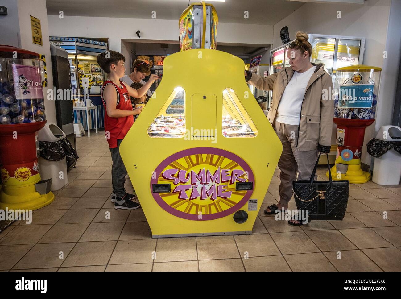 Menschen, die die Spielhallen genießen, spielen Spielautomaten in Goodrington Sands, Paignton Seaside Resort an der Küste von South Devon, Großbritannien Stockfoto