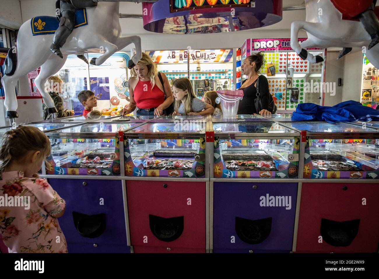 Menschen, die die Spielhallen genießen, spielen Spielautomaten in Goodrington Sands, Paignton Seaside Resort an der Küste von South Devon, Großbritannien Stockfoto