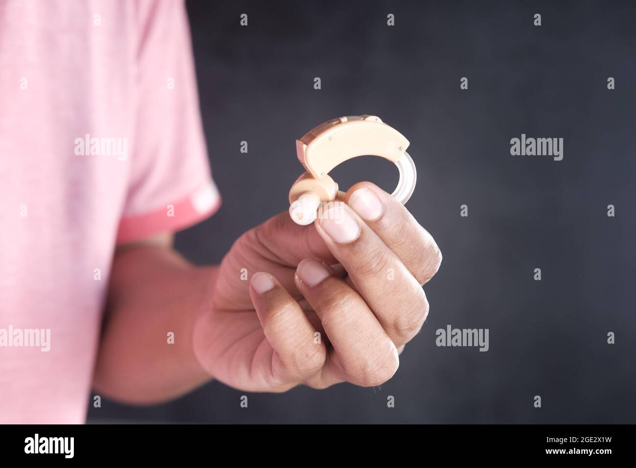 Hand halten Hörgeräte isoliert auf schwarz Stockfoto
