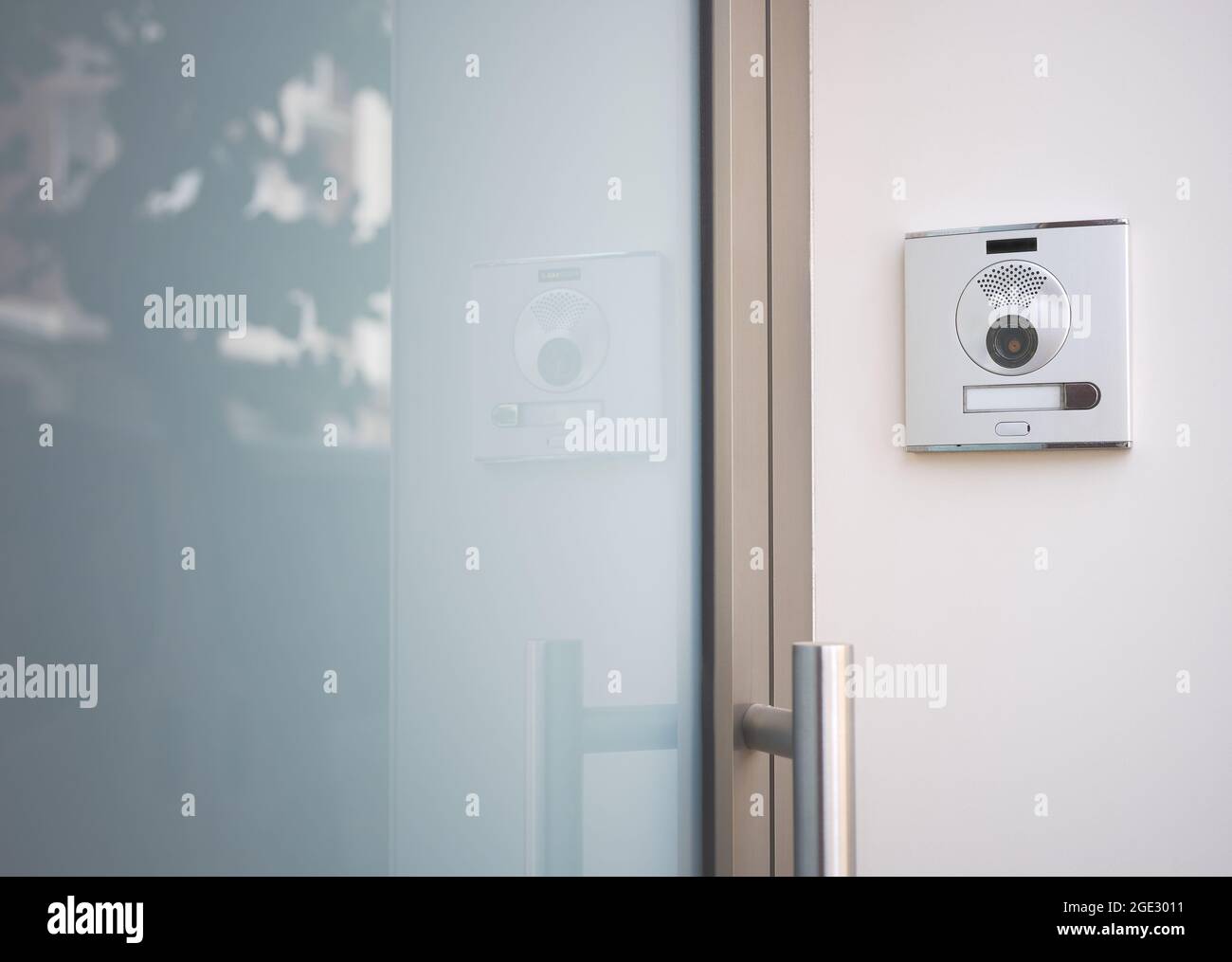 Detail einer Eingangstür zu einem Haus mit einer Türklingel mit Kamera Stockfoto