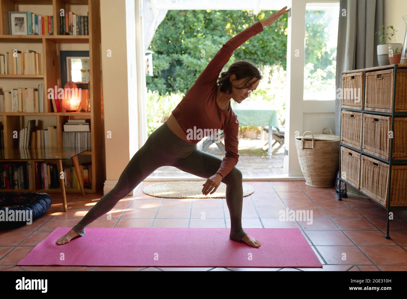Kaukasische Frau im Wohnzimmer, Yoga üben, Stretching Stockfoto