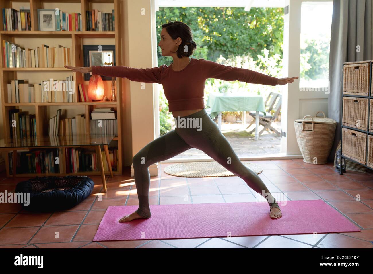 Kaukasische Frau im Wohnzimmer, Yoga üben, Stretching Stockfoto