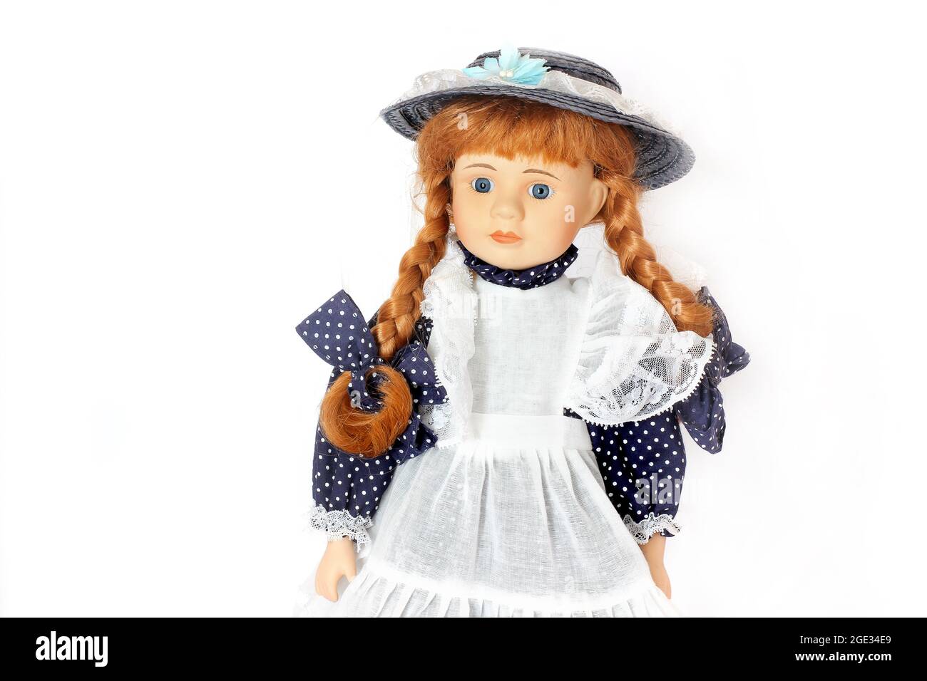 Wunderschöne Puppe. Puppe in einem blauen Kleid mit Schürze Stockfoto