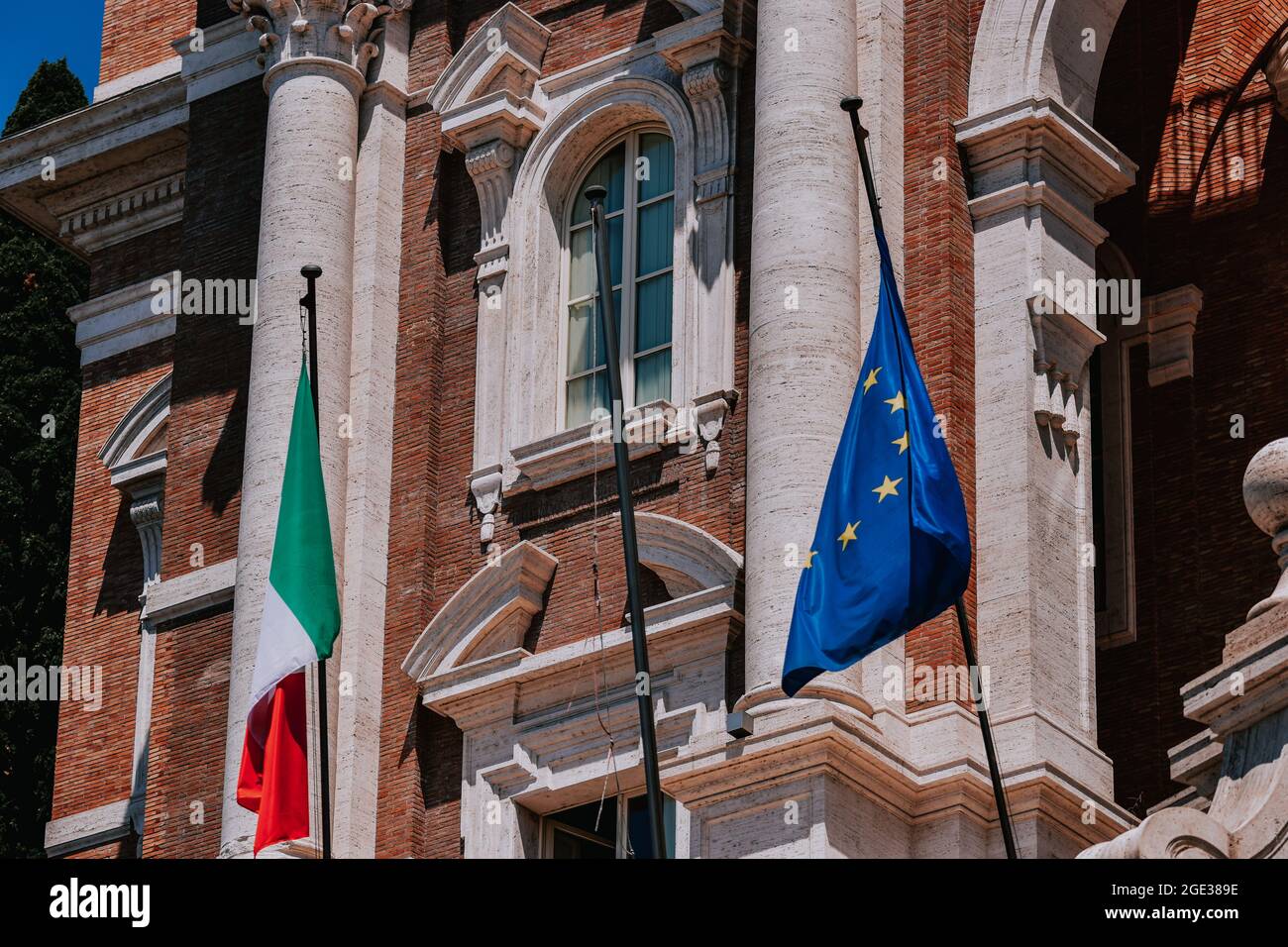 Nahaufnahme der italienischen und der EU-Flagge vor einem Backsteingebäude der Regierung in Rom Stockfoto