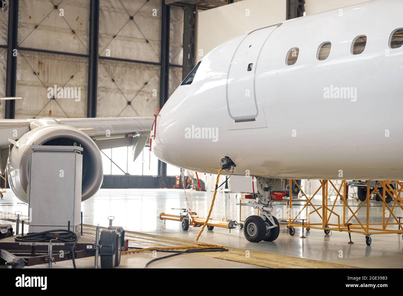Moderne neue weiße Passagierflugzeug auf Wartung Reparatur Check in Flughafen Hangar innen Stockfoto