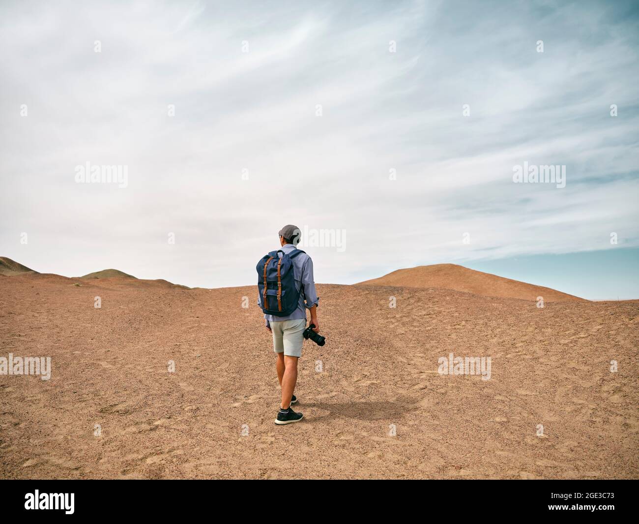 asiatischer männlicher Backpacker Landschaftsfotograf, der auf einem Hügel mit Blick auf die Rückansicht läuft Stockfoto