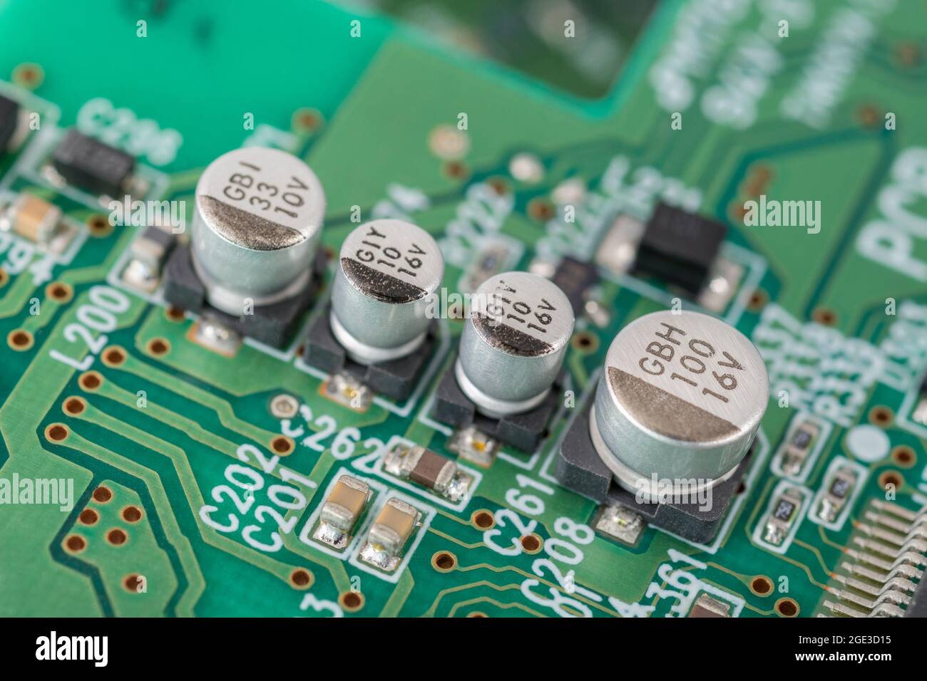 Nahaufnahme einer Reihe solider SMD-V-Chip-Hybrid-Aluminium-Elektrolytkondensatoren auf der leiterplatte mit schwarzer (minus) Polaritätsmarkierung. Marken nicht identifiziert Stockfoto