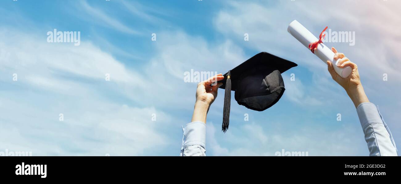 Absolvent mit Diplom und Kappe in den Händen auf blauem Himmel Hintergrund feiert College-Abschluss. Banner kopieren Raum Stockfoto