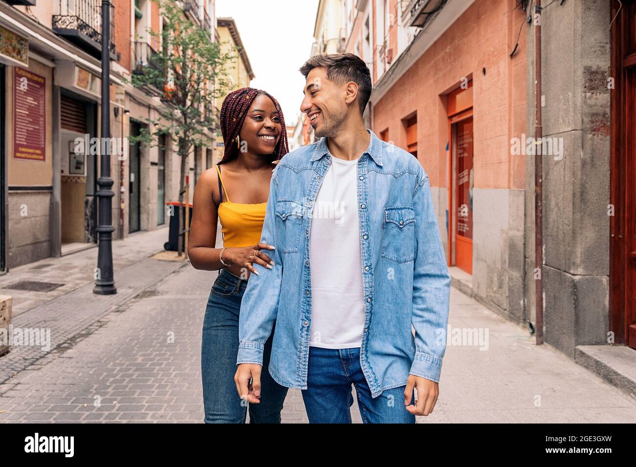 Multiethnisches junges Paar, das in den Straßen von Madrid spazierengeht und Spaß hat. Stockfoto