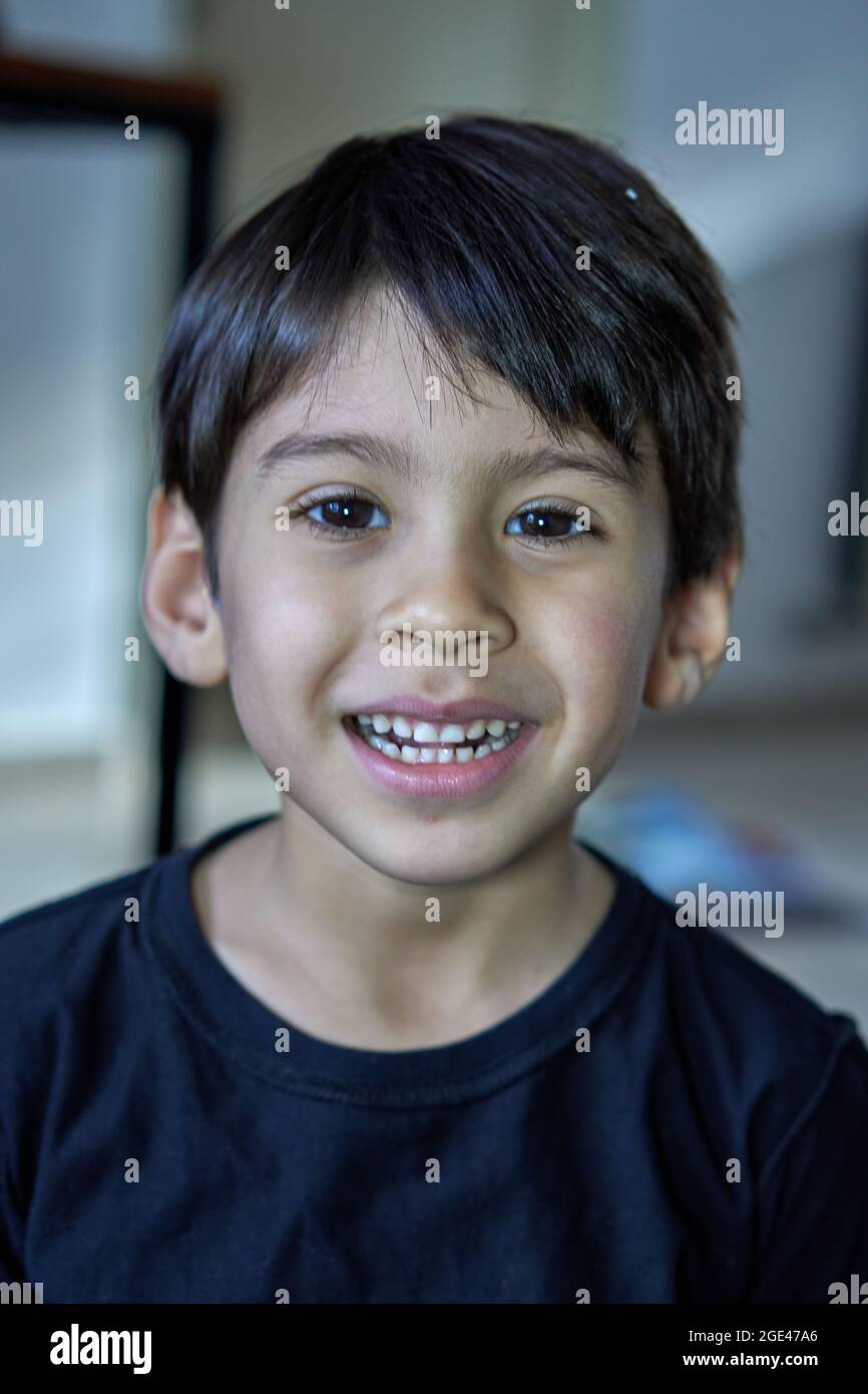 Nahaufnahme Porträt von gemischten Rennen Junge lächelnd. Brunette Kind glücklich. Vertikal Stockfoto