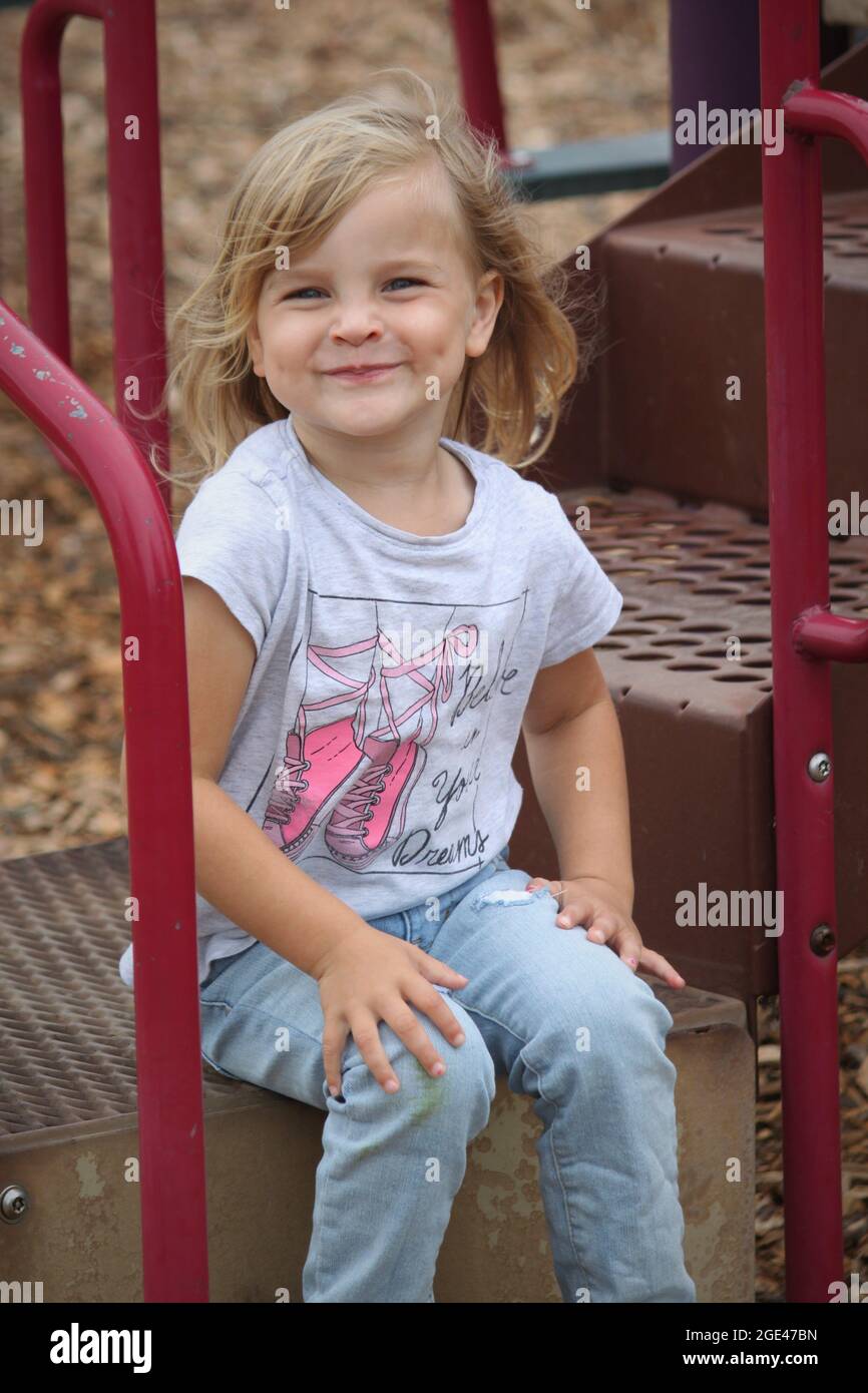 Kleines Mädchen mit Grübchen auf dem Spielplatz Stockfoto