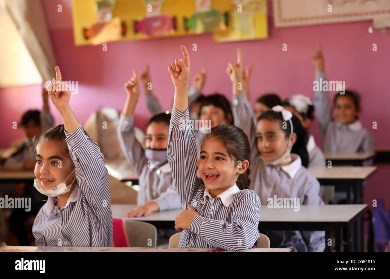 Nablus. August 2021. Am ersten Tag des neuen Schuljahres in Nablus, der Stadt im Westjordanland, heben die Schüler ihre Hände während eines Unterrichts am 16. August 2021. Mehr als eine Million Schüler aus dem Westjordanland und dem Gazastreifen sind am Montag nach mehrmonatiger Schließung der Schule aufgrund der Ausbreitung des Coronavirus in ihre Schulen zurückgekehrt. ZUM THEMA „Roundup: Neues Schuljahr beginnt in den palästinensischen Gebieten nach monatelanger Schließung der Schule“ Quelle: Ayman Nobani/Xinhua/Alamy Live News Stockfoto