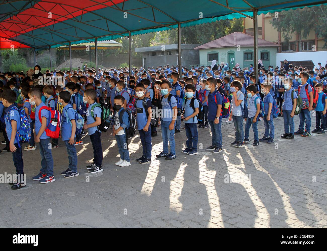 Gaza-Stadt. August 2021. Am ersten Tag des neuen Schuljahres in Gaza-Stadt, am 16. August 2021, stehen sich die Schüler an, um die Schule zu besuchen. Mehr als eine Million Schüler aus dem Westjordanland und dem Gazastreifen sind am Montag nach mehrmonatiger Schließung der Schule aufgrund der Ausbreitung des Coronavirus in ihre Schulen zurückgekehrt. ZUM THEMA „Roundup: Neues Schuljahr beginnt in den palästinensischen Gebieten nach monatelanger Schließung der Schule“ Quelle: Rizek Abdeljawad/Xinhua/Alamy Live News Stockfoto