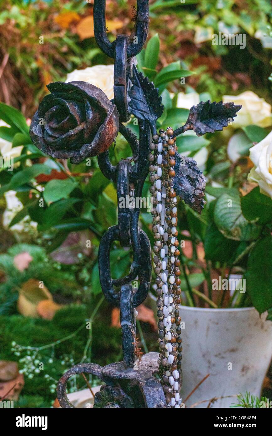 Rosenkranz hängt an einer schmiedeeisen Kette mit einer Rose Stockfoto
