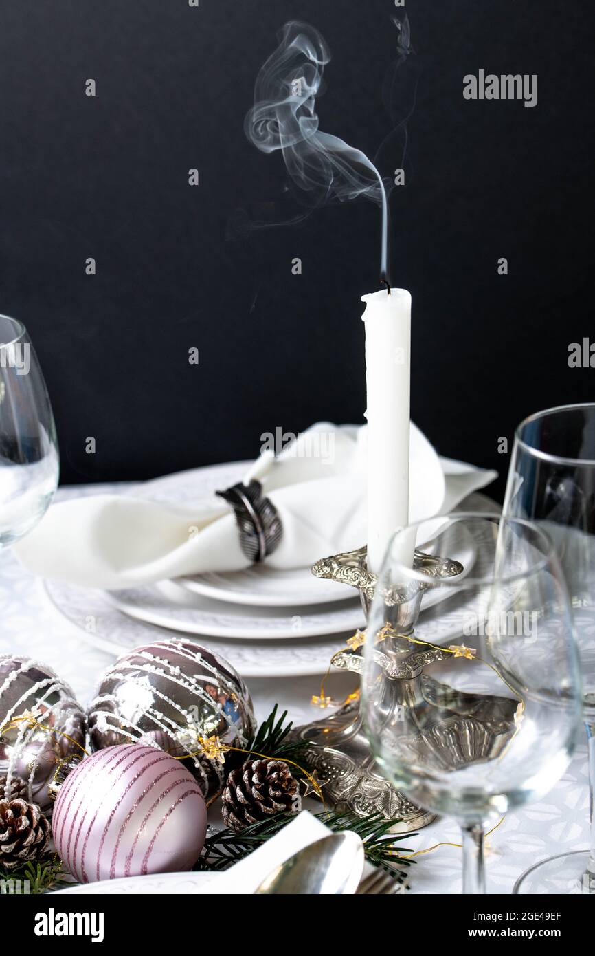 Weihnachtliche Tischkulisse mit weißen Servietten, antikem Splitterbesteck und Kerzenhaltern Stockfoto