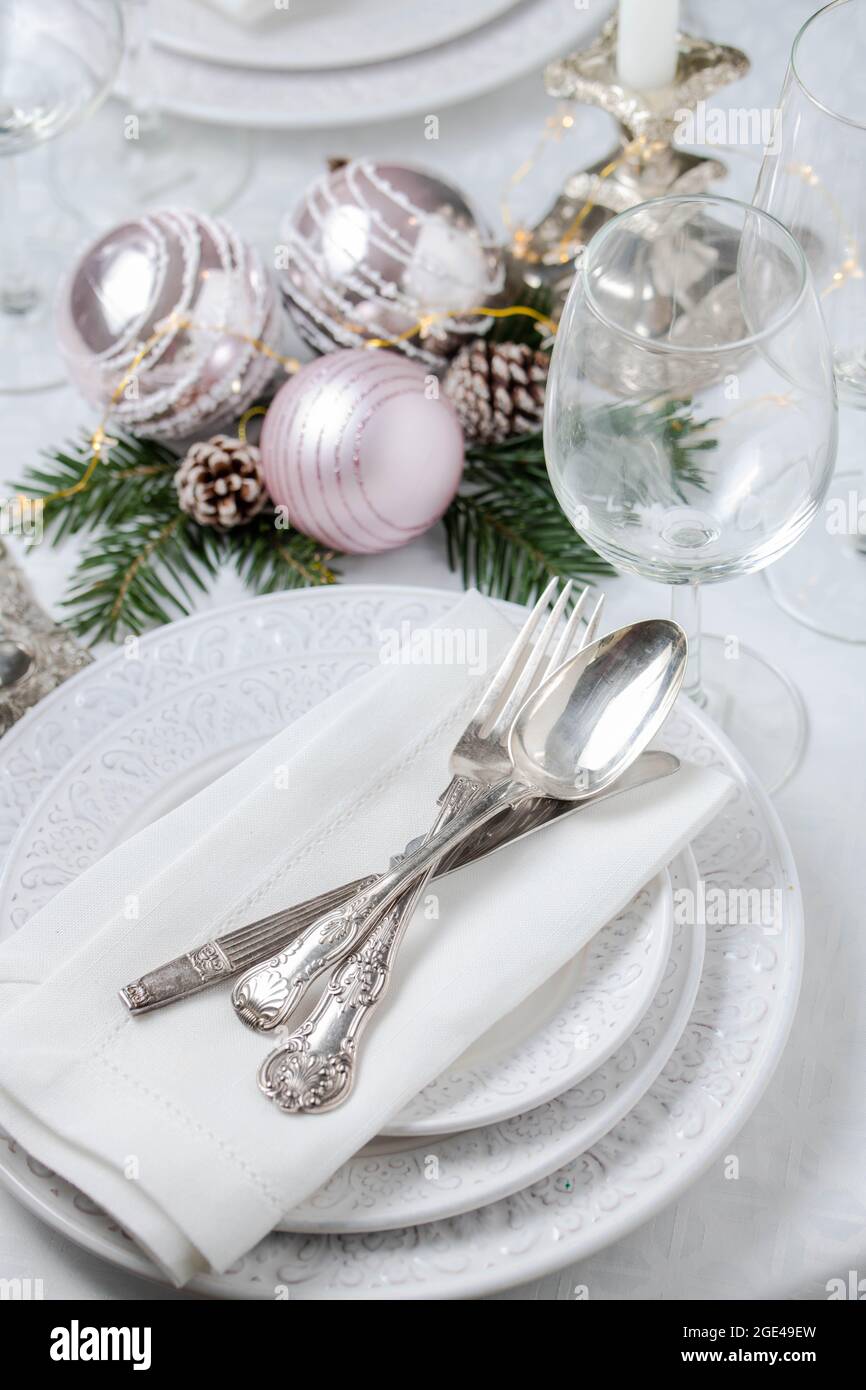 Weihnachtliche Tischkulisse mit weißen Servietten, antikem Splitterbesteck und Kerzenhaltern Stockfoto