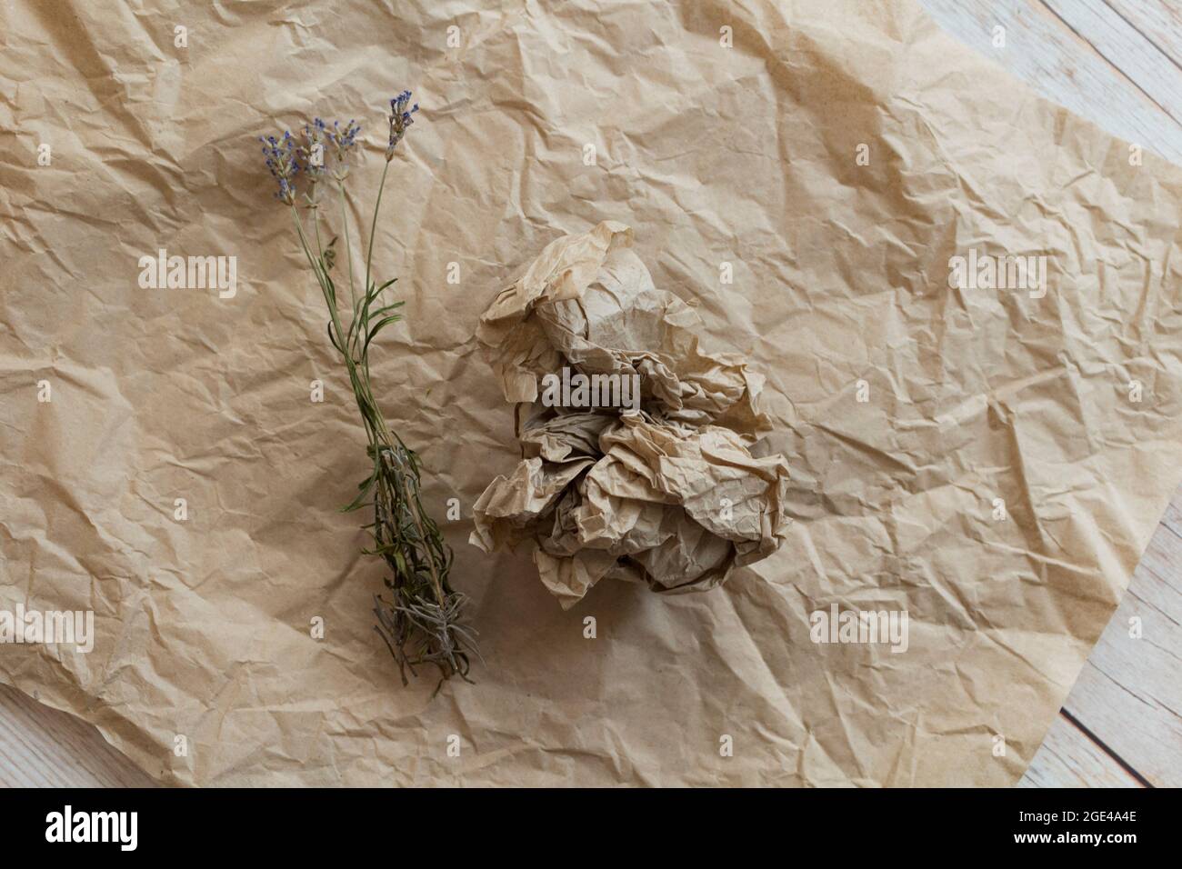 Getrocknete Lavendel-Zweige auf zerknittertem Kraftpapier. Hintergrund für einen Blumenladen, Website, im rustikalen Stil.Eco Lifestyle-Konzept mit organischen Materialien. Stockfoto