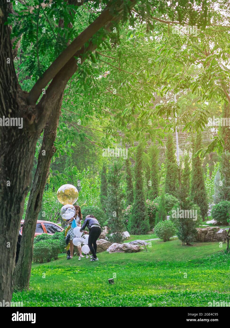KANCHANABURI, THAILAND - MAI 4,2020 : nicht identifizierte asiatische Frau und ihre Freundin mit großen gelben transparenten Latex-Ballons im Garten bei Mulberry Mellow. Stockfoto
