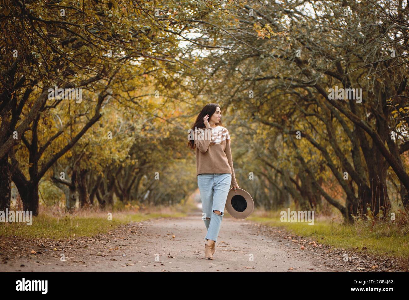 Schöne junge Frau, die im Herbstpark spazieren geht. Stockfoto