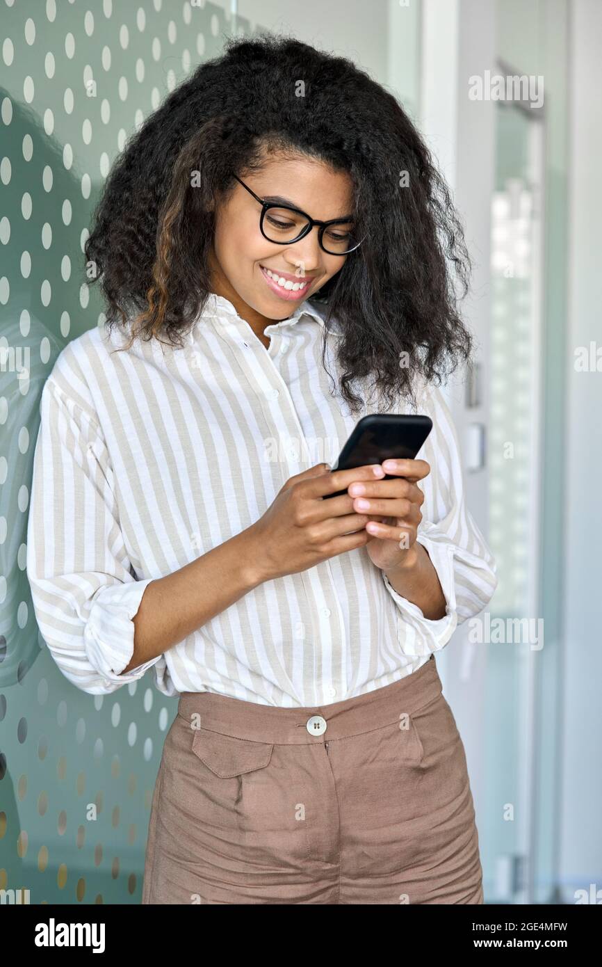 Lächelnde junge afroamerikanische Geschäftsfrau, die im Büro telefoniert. Stockfoto