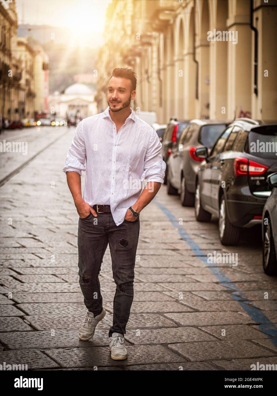 Junger Mann in der europäischen Stadtstraße zu Fuß Stockfoto