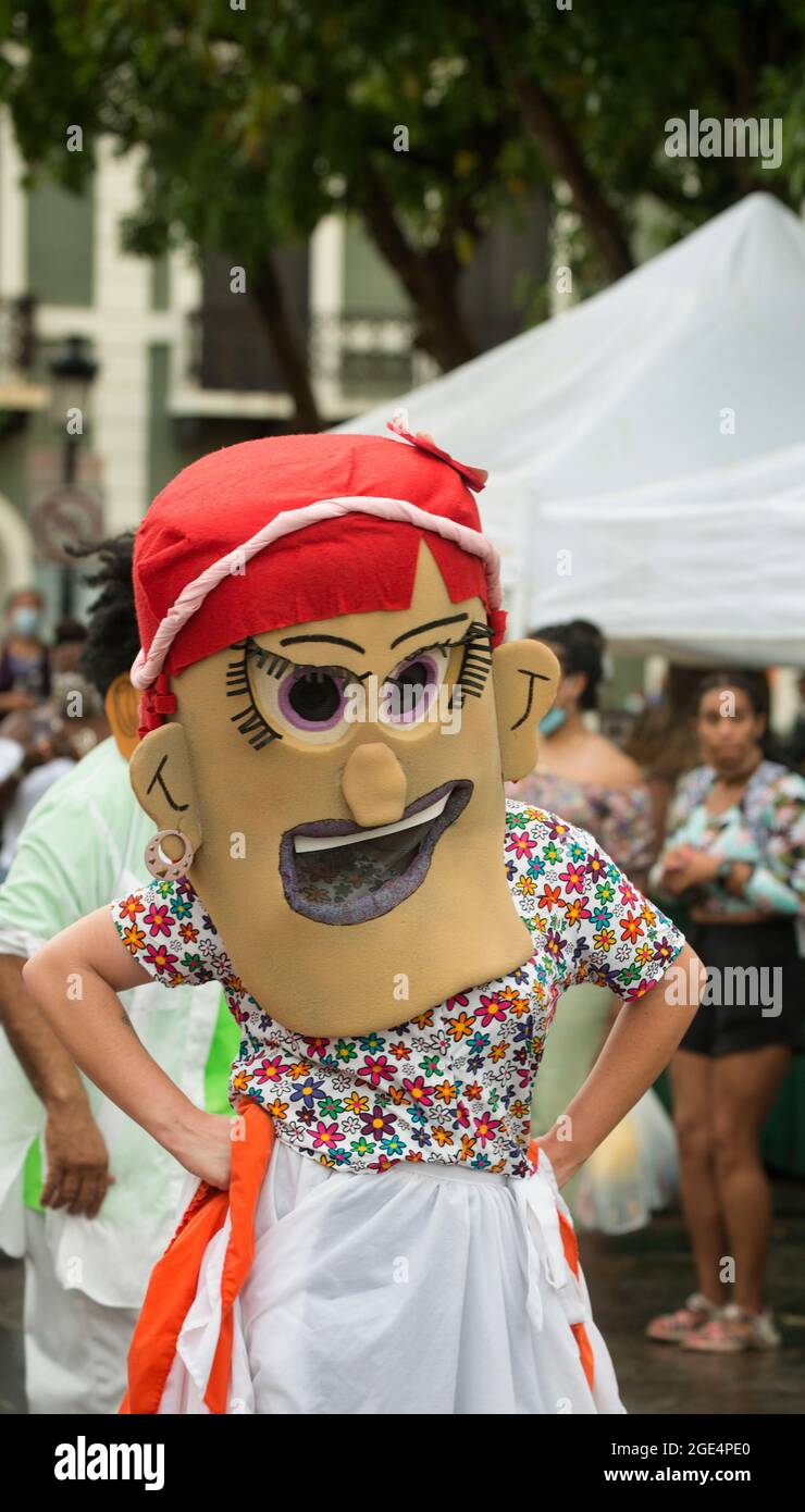 Cabezudos (Big Head) tanzen auf der De Armas Plaza nach einem Sommerregen in Old San Juan, Puerto Rico, USA. Stockfoto