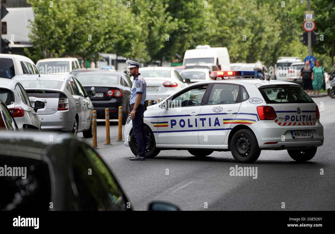 Bukarest, Rumänien - 12. August 2021: Ein Polizist lenkt Autos im Verkehr ab, um einen gesperrten Teil der Straße zu umgehen, weil ein Autounfall auf einem Boulevard in B stattgefunden hat Stockfoto