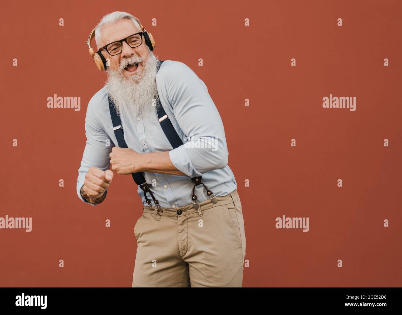 Senior Hipster Mann springen mit Kopfhörern und Smartphone Musik aus der Wiedergabeliste genießen - ältere Mann haben Spaß mit der Technologie Stockfoto