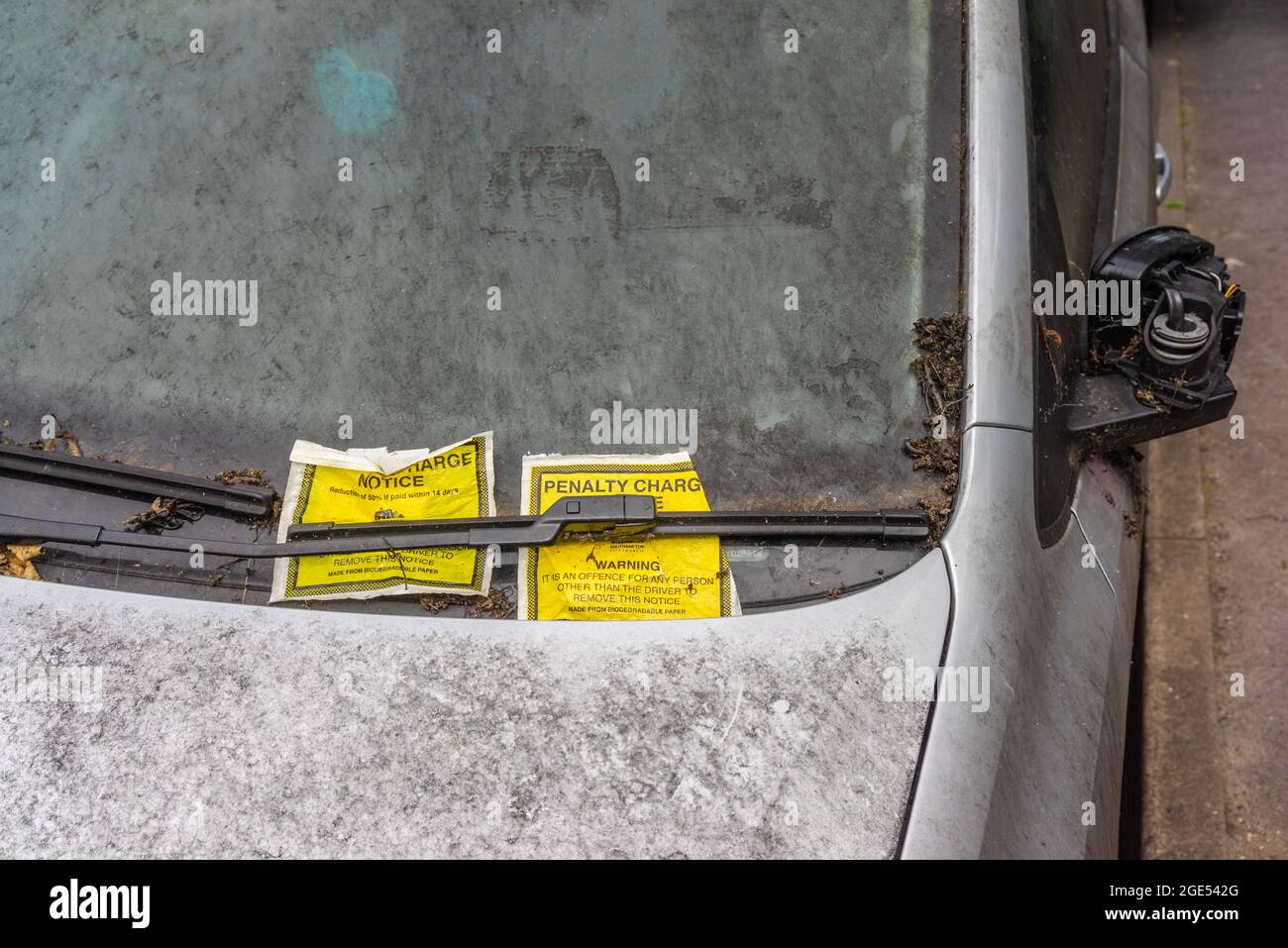 Verlassene Autos mit zwei Entgeltanzeigen an einer schmutzigen Windschutzscheibe, England, Großbritannien Stockfoto