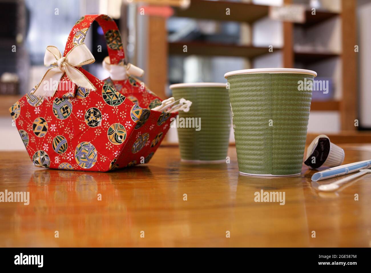 Nagano, Japan, 2021-10-08 , zwei Pappbecher gefüllt mit Kaffee und einem roten Korb mit Zucker und Creme. Stockfoto