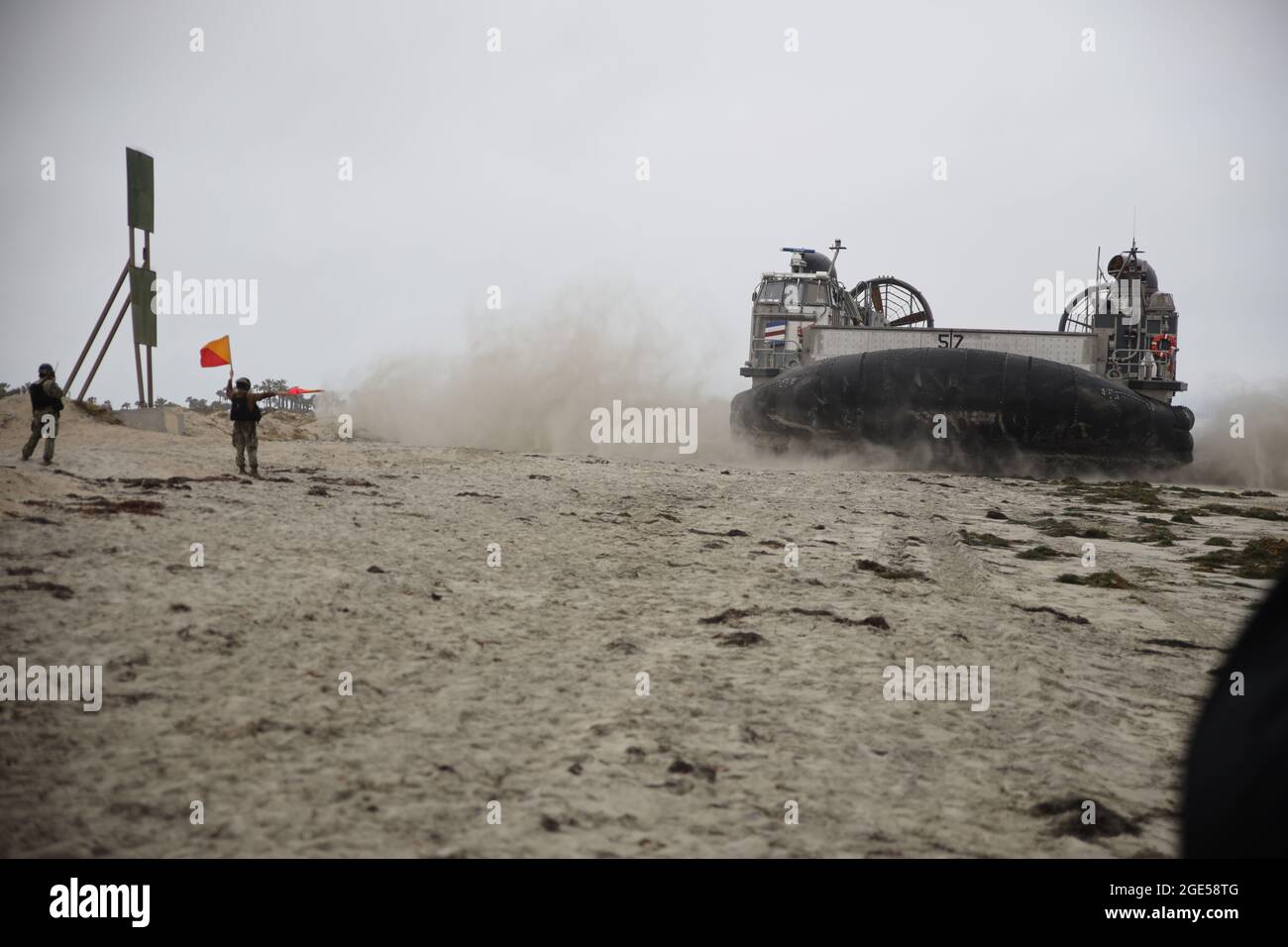 Ein luftgedämpftes Landungsschiff (LCAC), das der Assault Craft Unit Five (ACU-5) zugewiesen wurde, wird von Seglern der Beach Masters Unit One (BMU-1) vor dem Silver Strand in Coronado, CA, geführt. Stockfoto