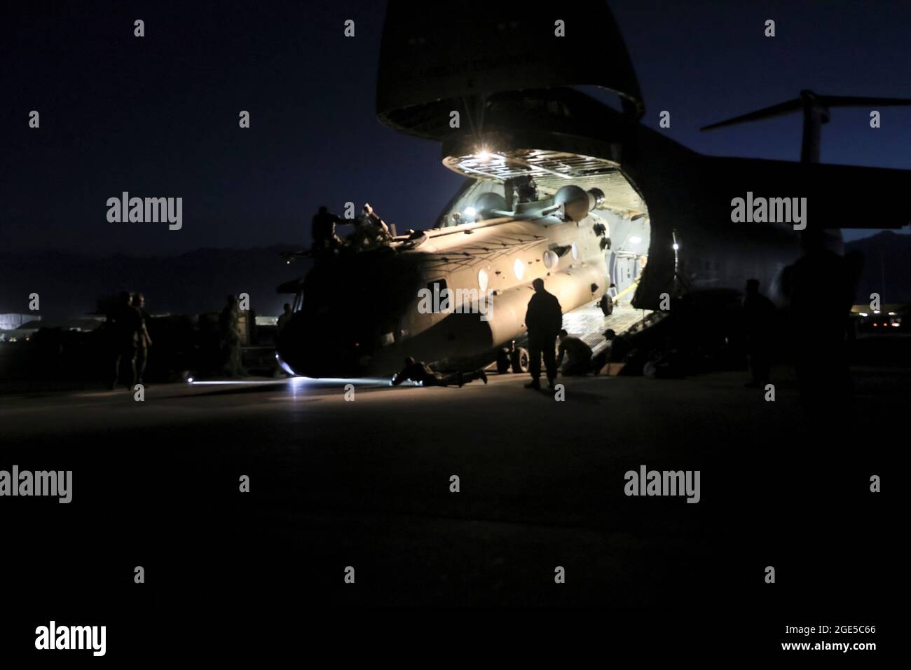 Antennenporteure arbeiten mit Betreuern zusammen, um einen CH-47 Chinook in einen C-17 Globemaster III zu laden, um die rückwirkende Mission Resolute Support in Afghanistan zu unterstützen, 16. Juni 2021. (USA Armeefoto von Sgt. Klasse Corey Vandiver) Stockfoto