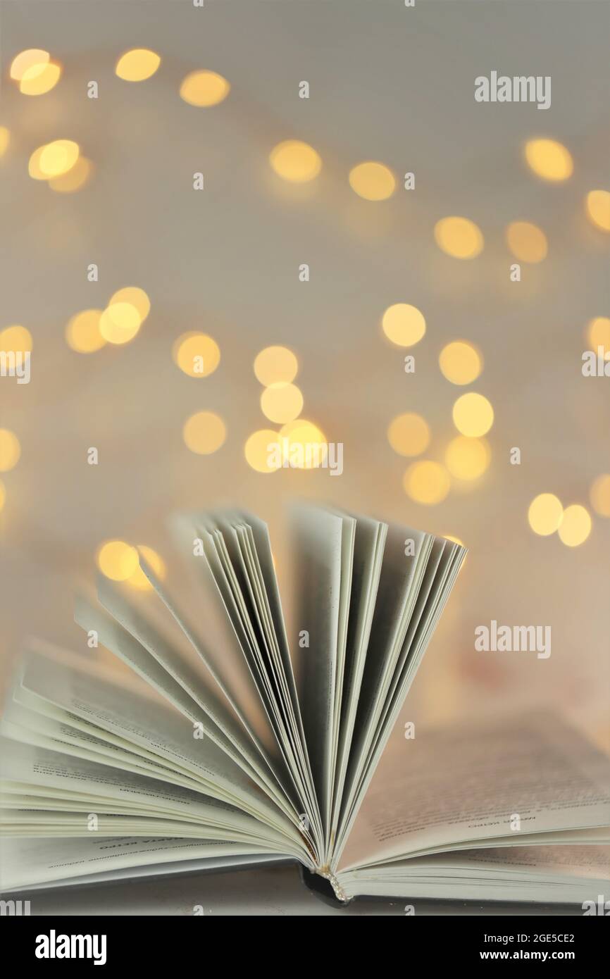 Bücher lesen. Buchseiten auf leuchtendem Bokeh-Hintergrund.Winterbücher. Weihnachtsbücher.Winter gemütliches Lesen.Buch der Märchen Stockfoto