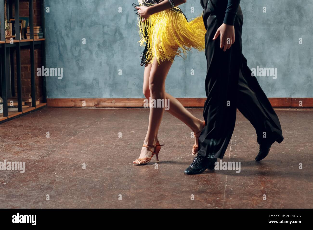 Tanzsamba im Ballsaal. Junges Paar in gelben und schwarzen Kostümen tanzend Stockfoto
