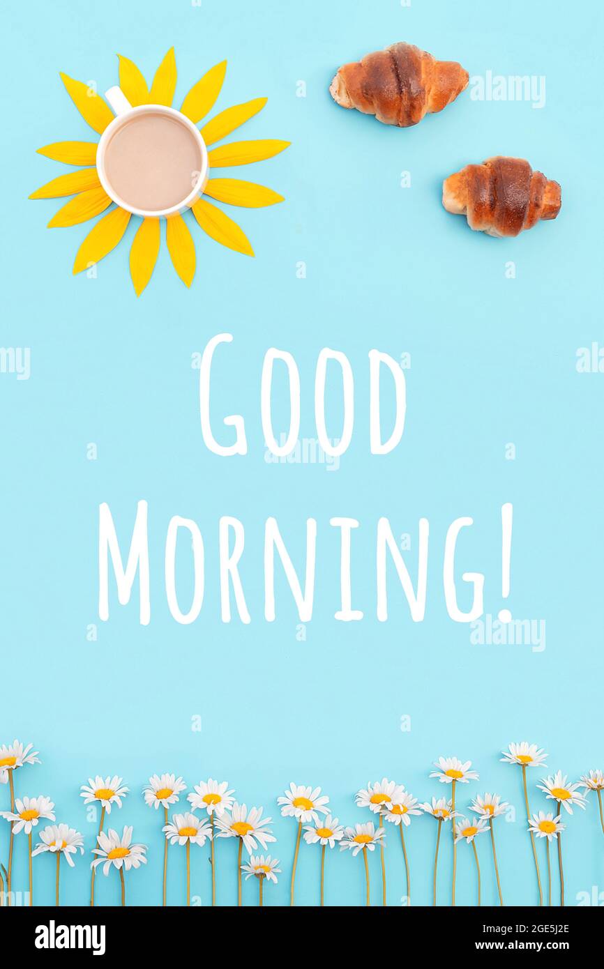 Kreatives Konzept von Guten Morgen. Kaffee, Croissants und Kamillenblumen auf blauem Hintergrund. Frühstück für gute Laune. Stockfoto