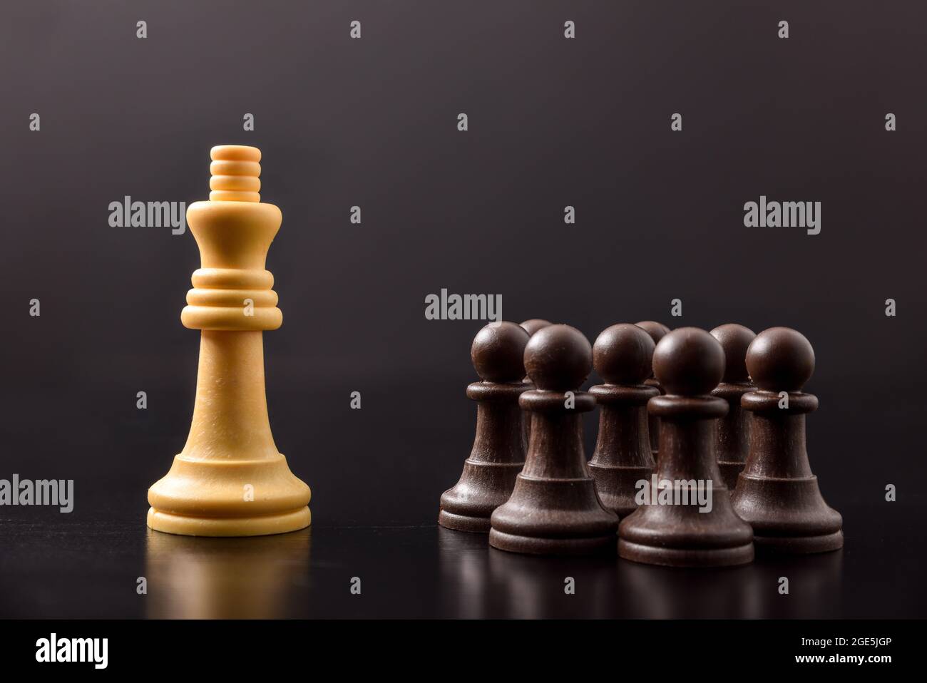 Beherrschung von Macht und Massenkontrolle und Klassen unter Männern mit Konzept mit Schachfiguren auf schwarzem Tisch und Hintergrund Stockfoto