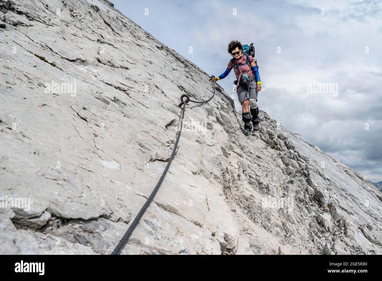 Wanderer bergab felsiges Gelände, Wanderweg gesichert mit Stahlseil, Heilbronner Weg, Allgäu Alpen, Allgäu, Bayern, Deutschland Stockfoto