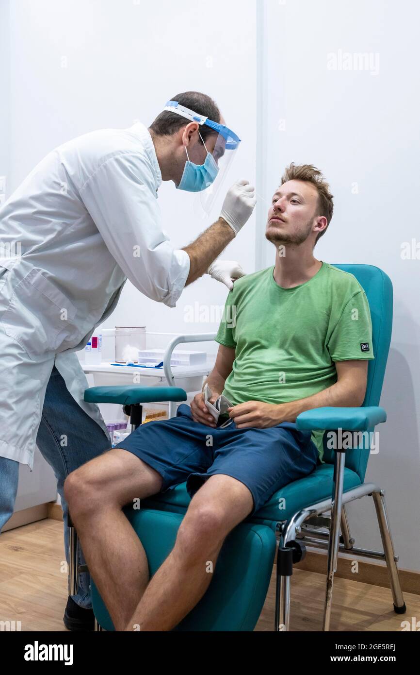 Arzt in Schutzkleidung führt einen Antigen-Test an einem jungen Mann durch, Coronavirus-Test, Covid-19, Kalymnos, Griechenland Stockfoto