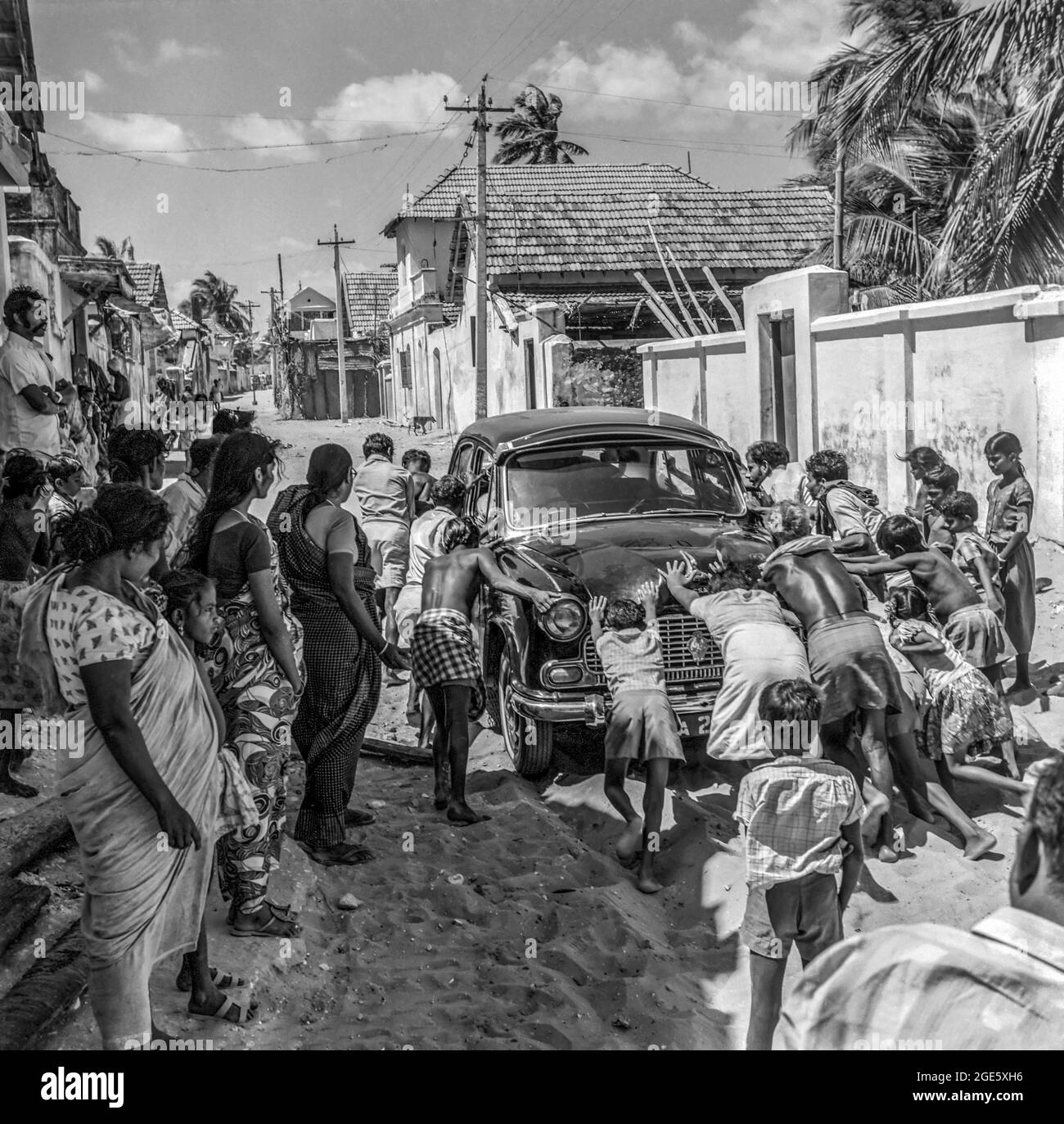 Indische Leute schieben ein Auto, um in Manappad Sand, Tamil Nadu, Indien, anzufangen Stockfoto