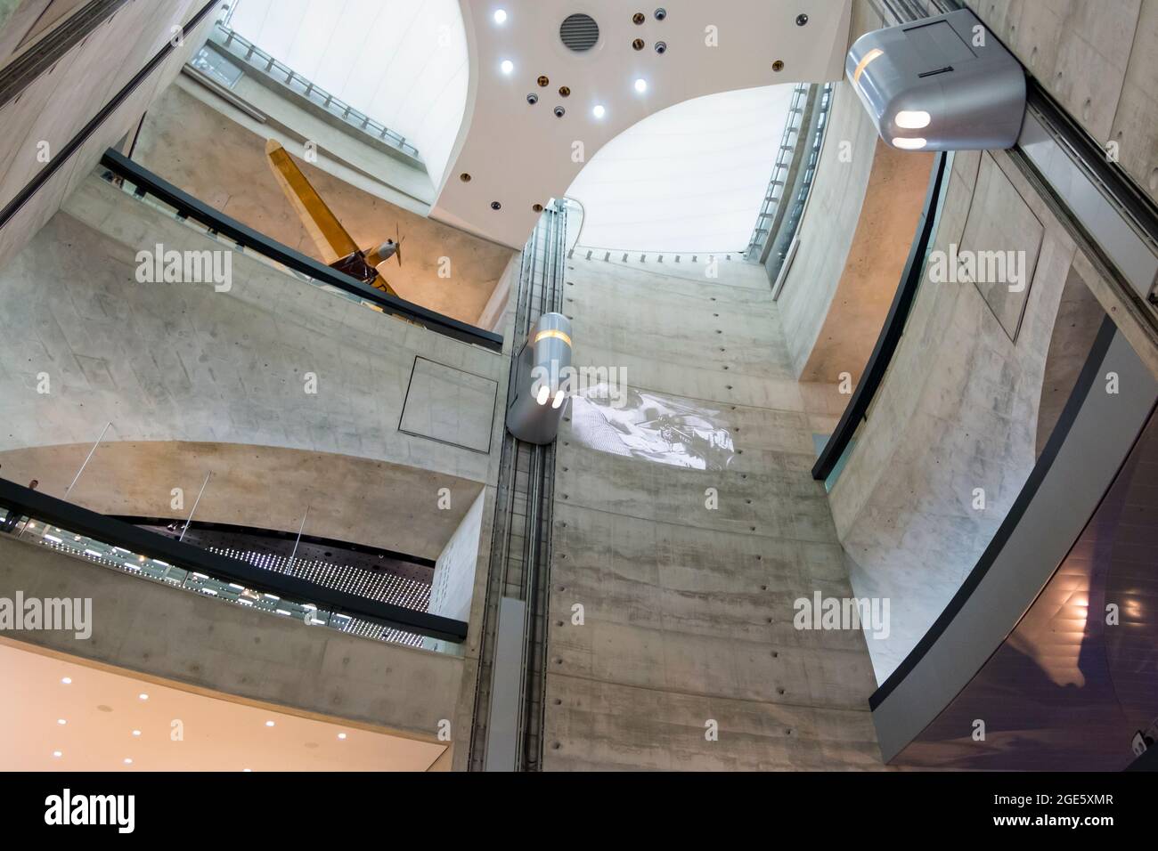 Das hoch aufragende, moderne, brutale Betonatrium mit silbernen Aufzügen. Im Mercedes-Benz Museum in Stuttgart. Stockfoto