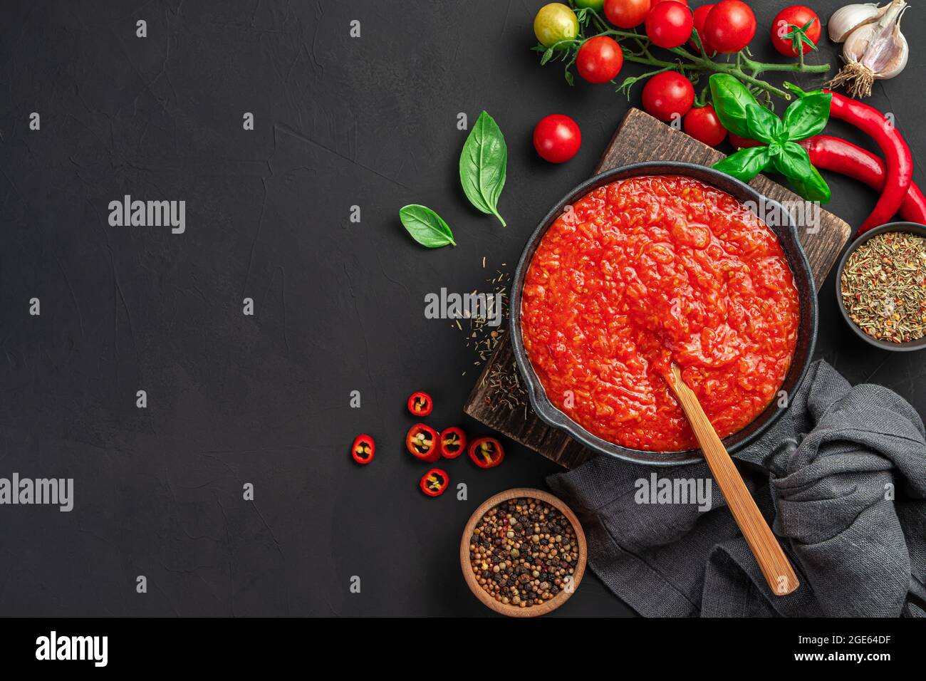 Italienische Tomatensauce, Pasta-Dressing, Pizza in einer Pfanne auf schwarzem Hintergrund. Stockfoto