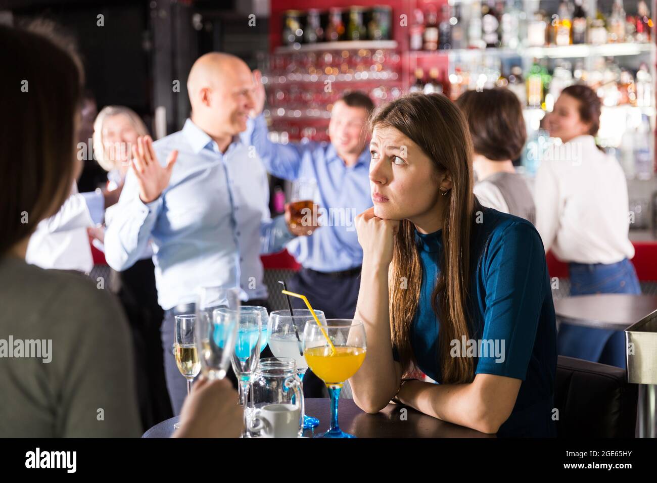 Verärgerte junge Frau bei der Firmenfeier in der Bar Stockfoto