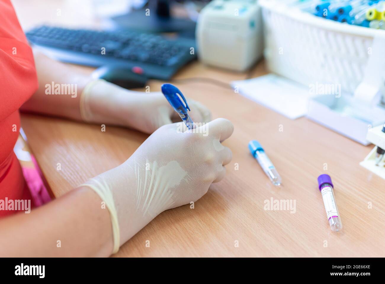 Wissenschaftler schreiben auf Reagenzgläsern in einer Laborklinik vor verschwommenem Hintergrund. Stockfoto