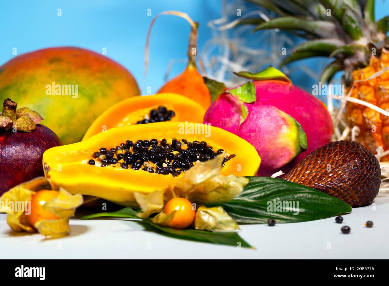 Papaya, Drachenfrucht, Mango, Mangostan, Winterkirsche, Granadilla, Salak und Ananas. Frische Tropische Früchte. Auf blauem Hintergrund. Draufsicht. Obst Stockfoto