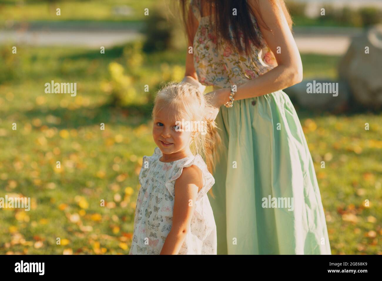 Portrait von glücklicher liebevoller Mutter und ihrem kleinen Mädchen im Freiluftherbstpark. Stockfoto