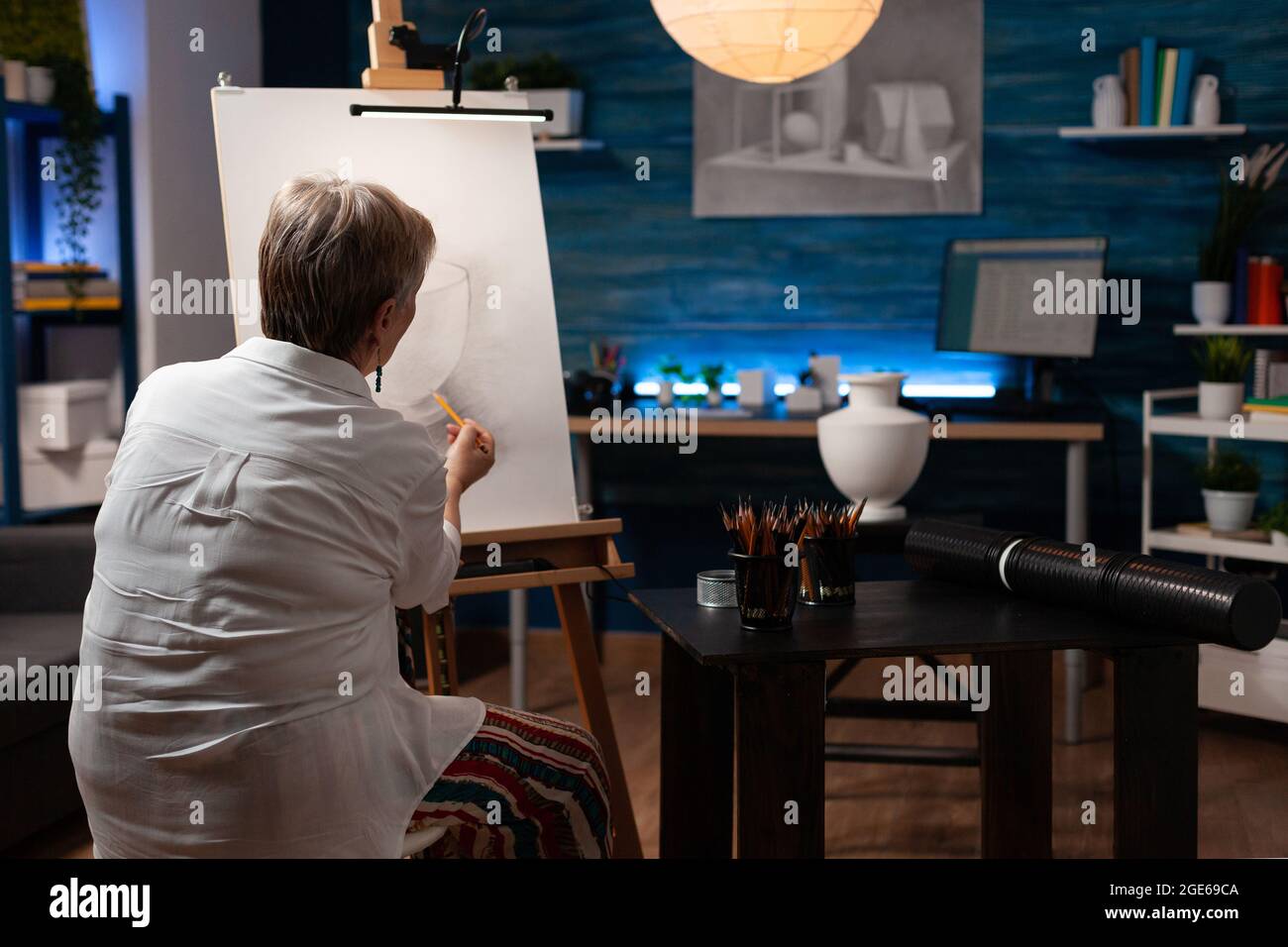 Kaukasisch alter Künstler, der mit Vase und Bleistift auf Leinwand für authentisches Zeichnen in der Werkstatt arbeitet. Ältere Frau mit künstlerischem Hobby Meisterwerk für Bildende Kunst-Projekt im Studio zu schaffen Stockfoto