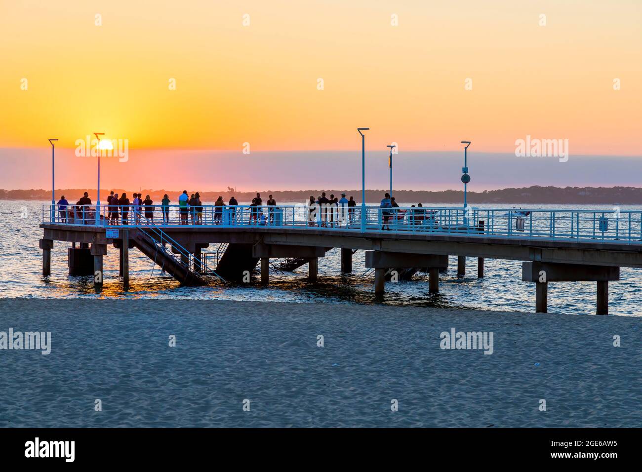 Arcachon (Südwest-Frankreich): Touristen genießen den Sonnenuntergang über dem Atlantik vom Pier am Strand „Plage du Moulleau“ Stockfoto
