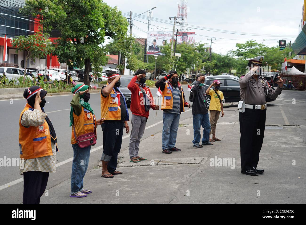 Makassar, Indonesien, 17. August 2021. Ein Polizist in Makassar feiert den 76. Indonesischen Unabhängigkeitstag auf einzigartige Weise. Dieser Polizist lud die Parkwächter ein, die Zeremonie virtuell durchzuführen, während er ein Mobiltelefon ansah, das eine Live-Übertragung der Flaggenzeremonie im Staatspalast ausstrahlte. Quelle: Herwin Bahar/Alamy Live News Stockfoto