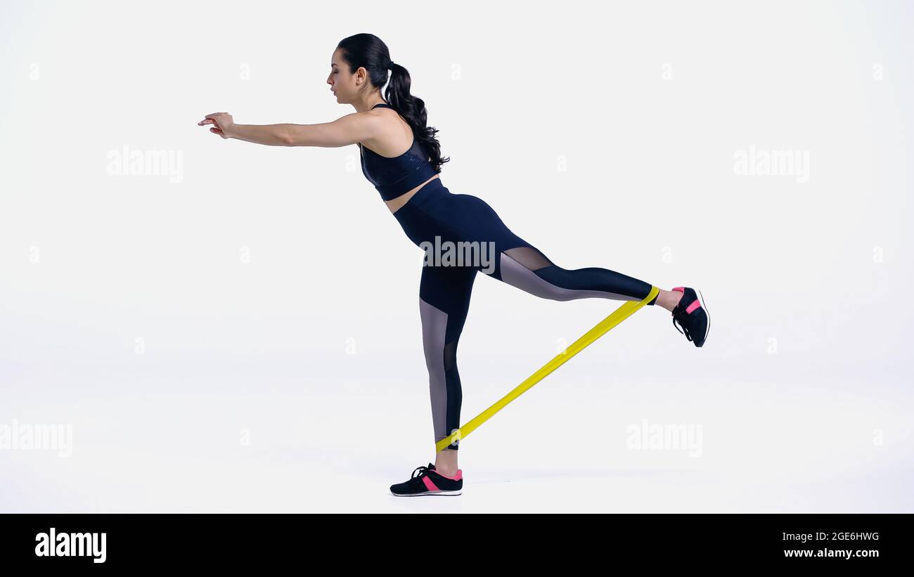 Seitenansicht des Trainings der Sportlerin mit Gummibeinen auf Weiß Stockfoto