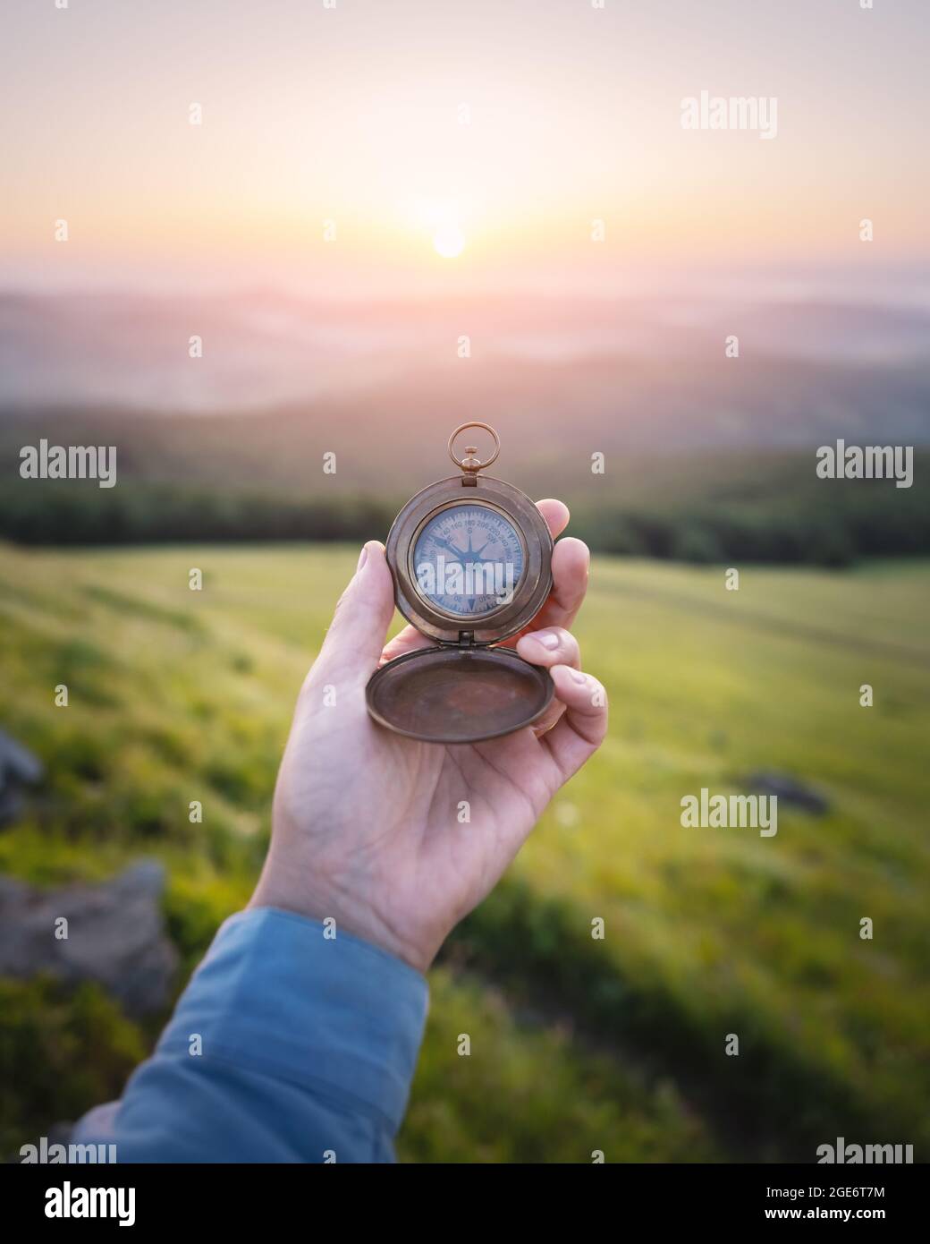 Mann mit Kompass in der Hand auf den Bergen unterwegs. Travel Concept. Landschaftsfotografie Stockfoto